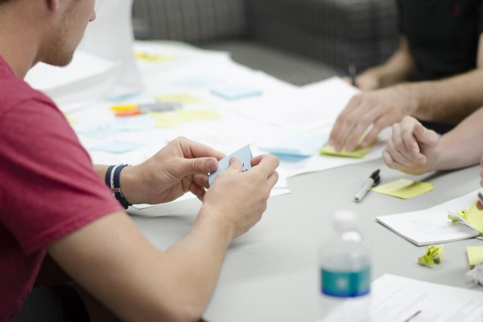 A team mapping work out on sticky notes around a table