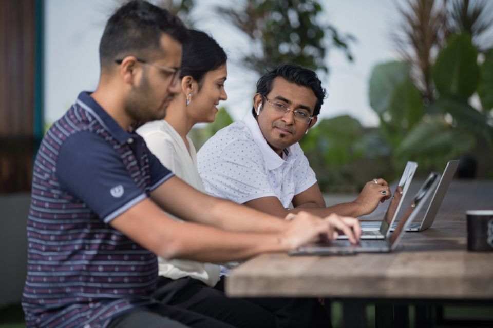Two colleagues reviewing work together at a laptop